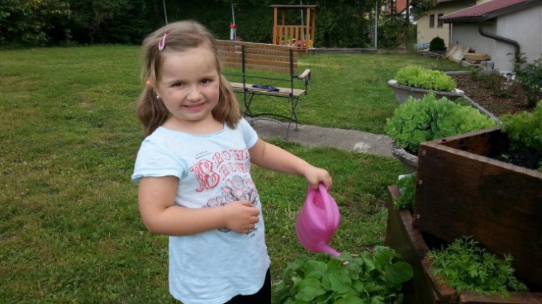 Kind gießt Gemüsepyramide