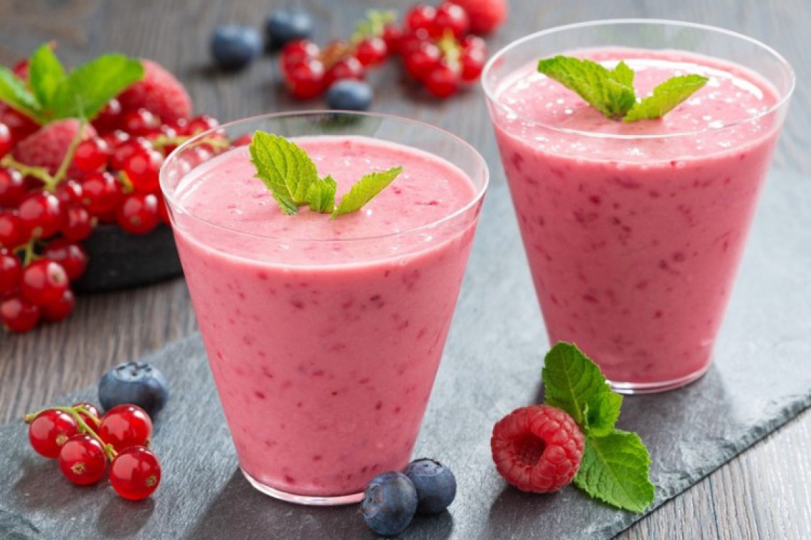 Beerenshake mit Minzblätter auf einer Schieferplatte 