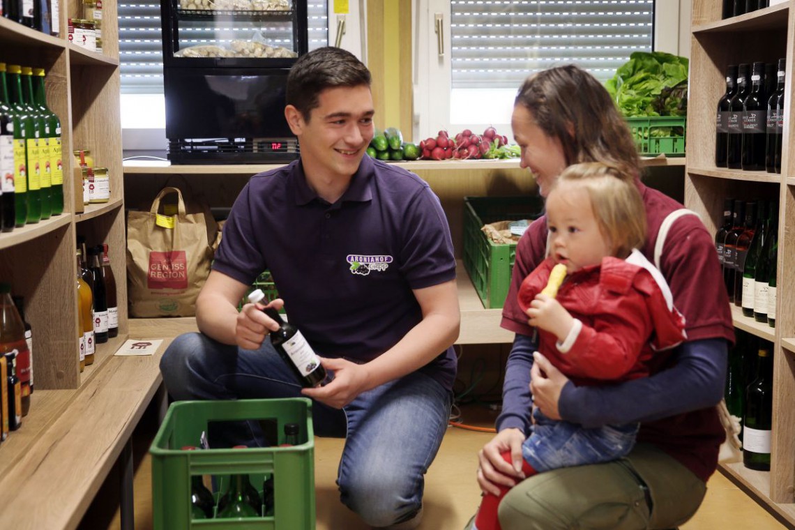 Familie sitzt im Bauernladen Simonsfeld und beraten sich über die Produkte