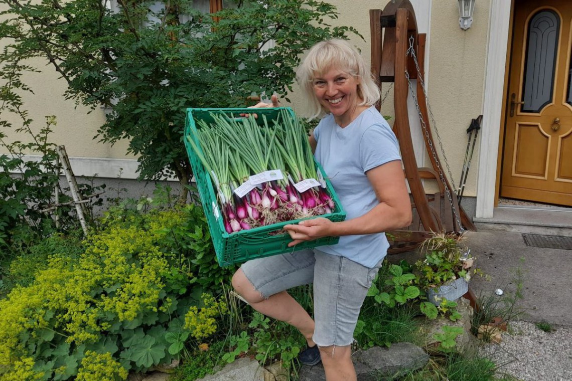 Christa Eppensteiner mit einer Kiste Jungzwiebel