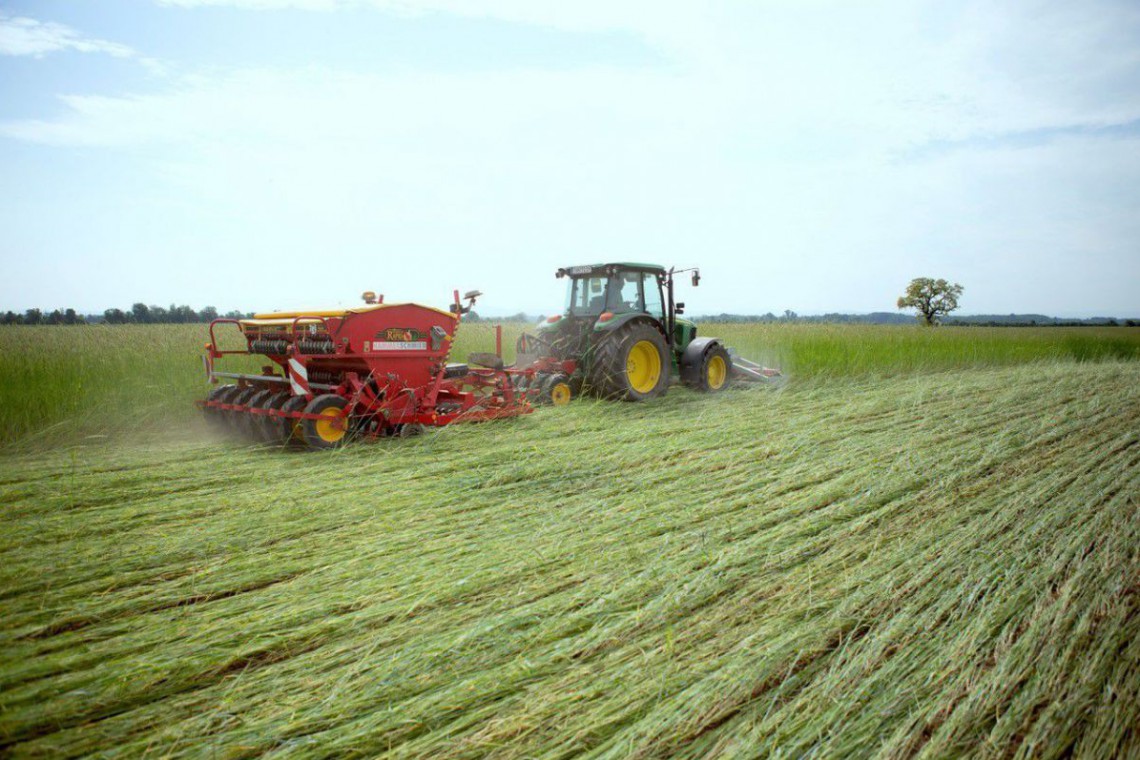 Grand Farm, ein Traktor mit Zugmaschine am Feld