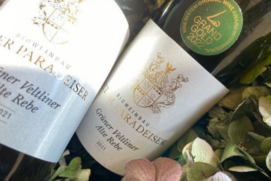 Bioweinbau Peter Paradeiser, zwei Weinflaschen im Blumenbett