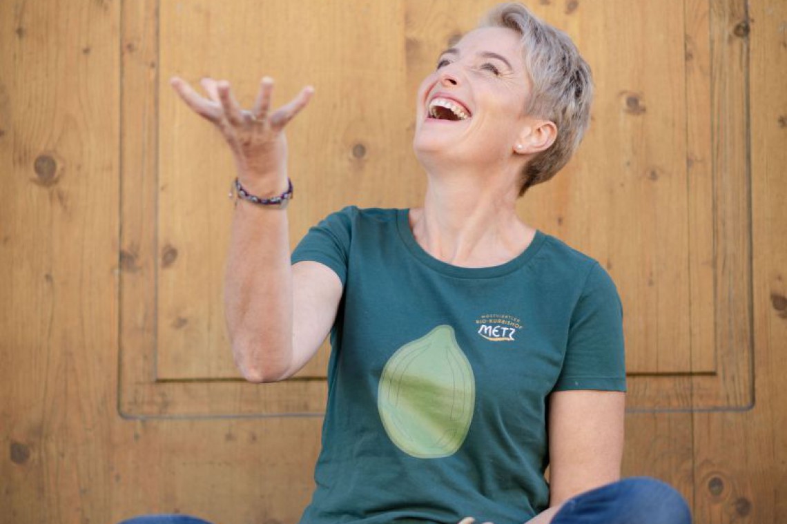 Kürbishof Metz, Karin Metz sitzend mit Kürbis