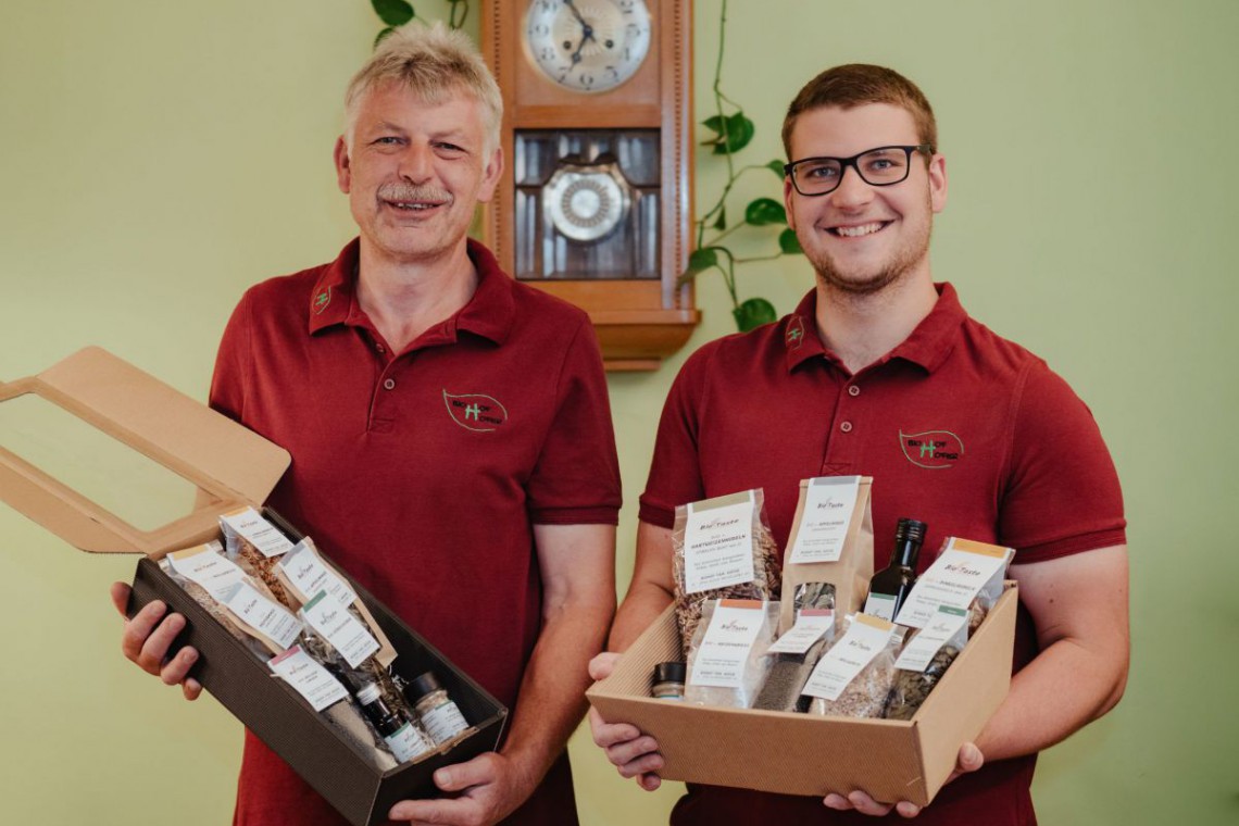 Biohof Hofer, Familie Hofer präsentiert Geschenkkartons gefüllt mit eigenen Produkten