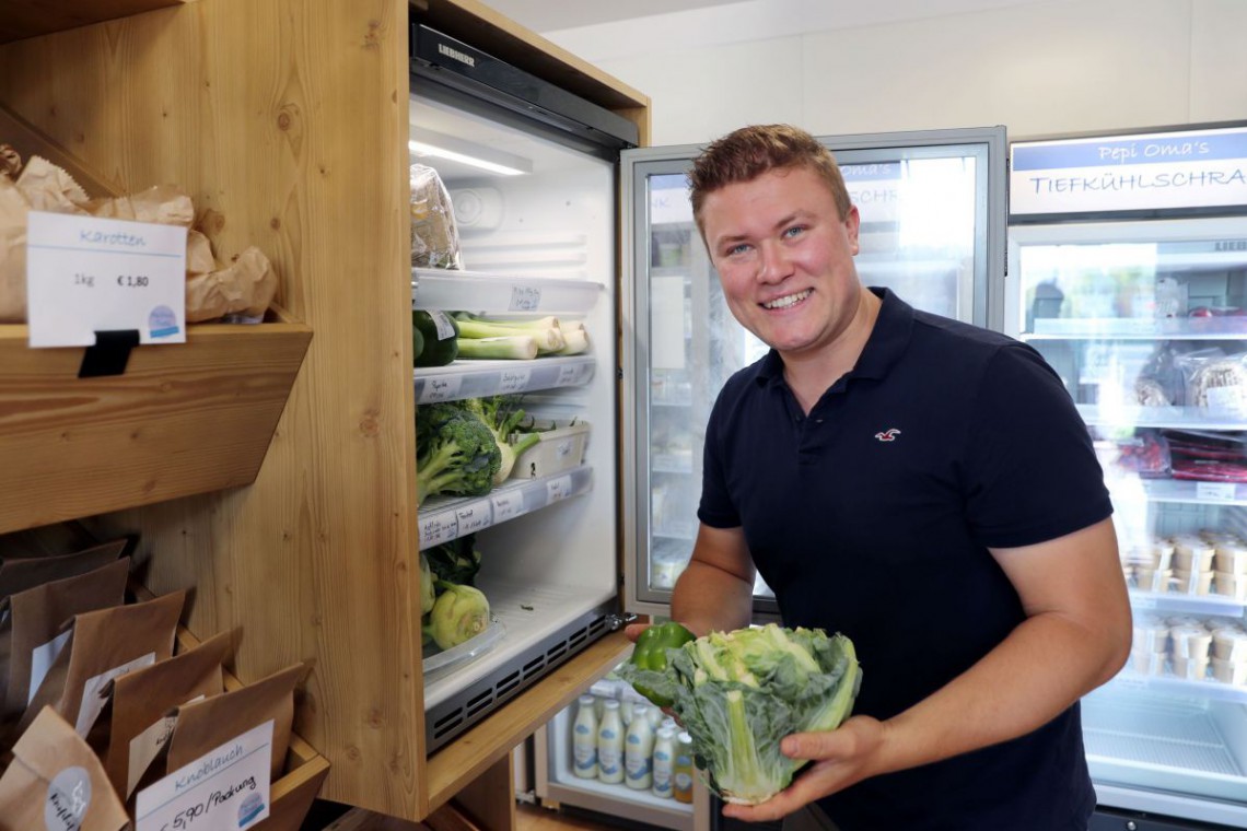 Pepi Omas Speis, Herr Burger mir Karfiol in der Hand vor dem Kühlschrank im Verkaufsladen