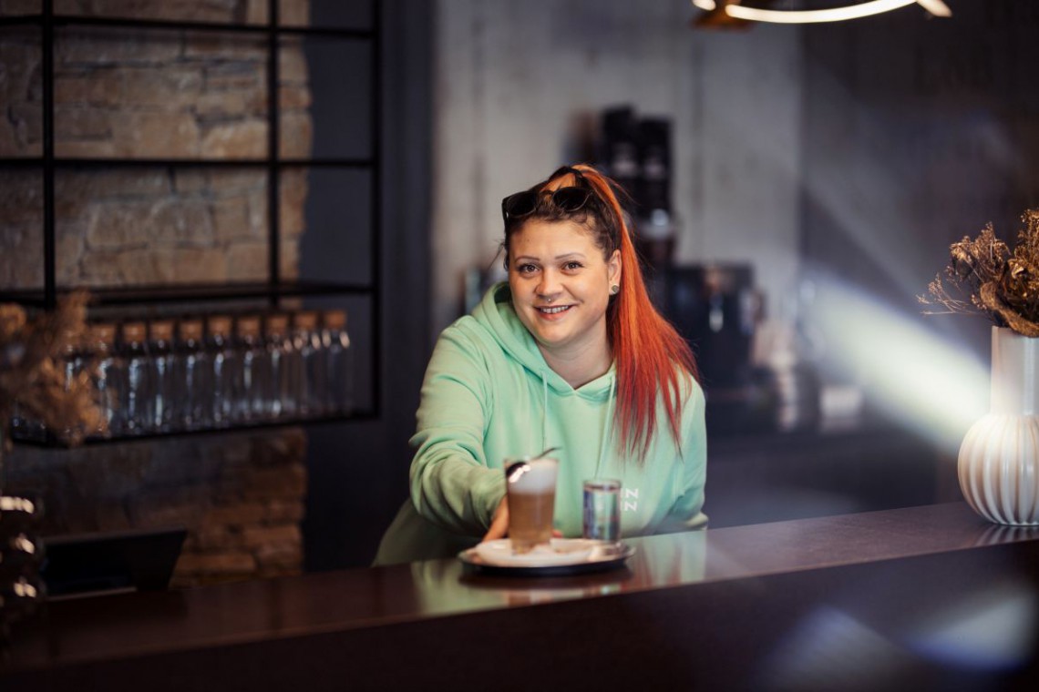 Bedienung stellt Kaffee auf die Theke