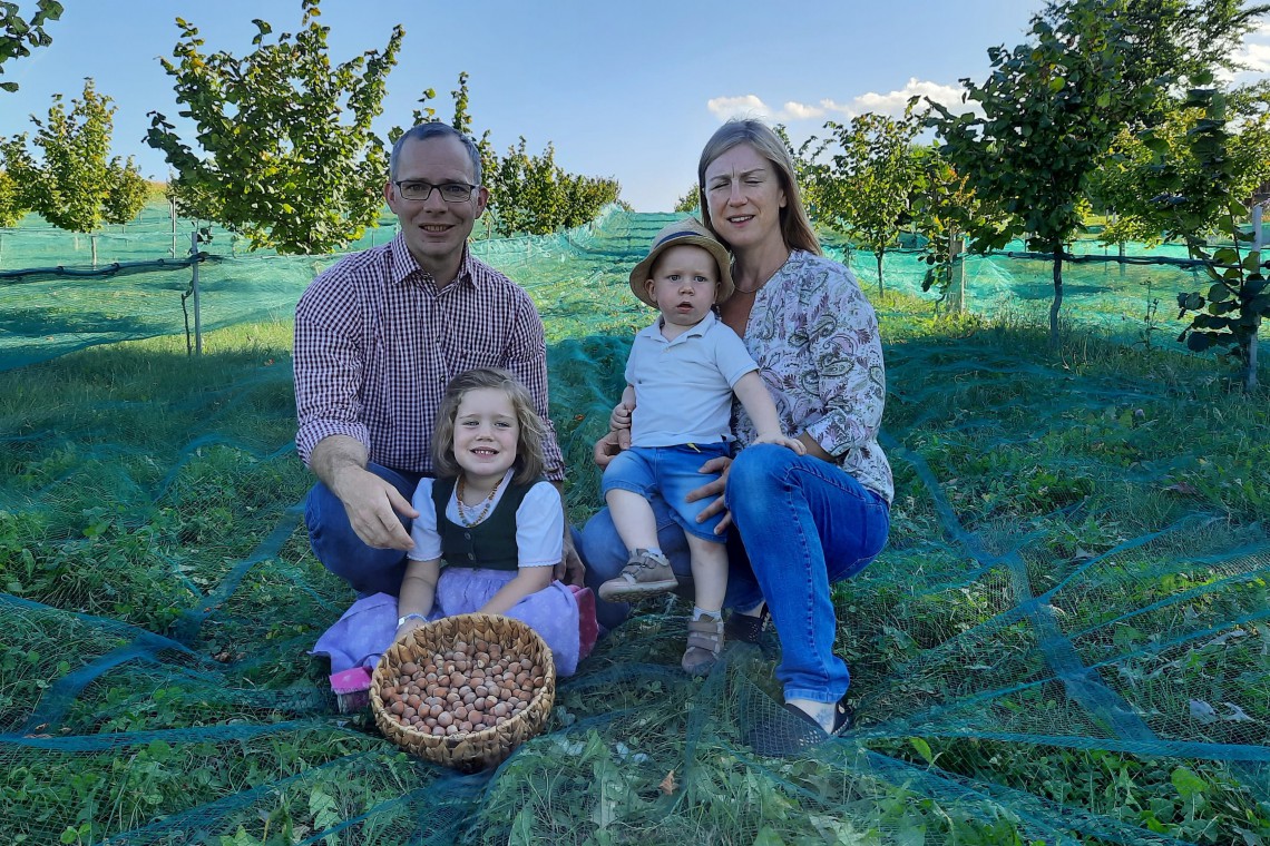 Familie Rausch auf wiese mit Korb voll Haselnüssen