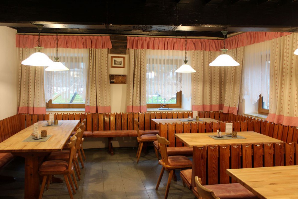 Gem&uuml;tliche Gaststube mit Tischen und B&auml;nken