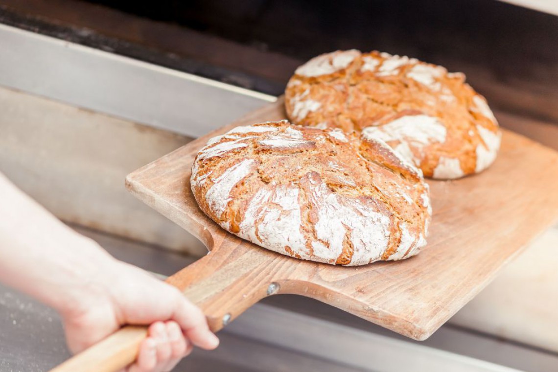 Zwei Laib Brot die gerade in den Ofen geschoben werden