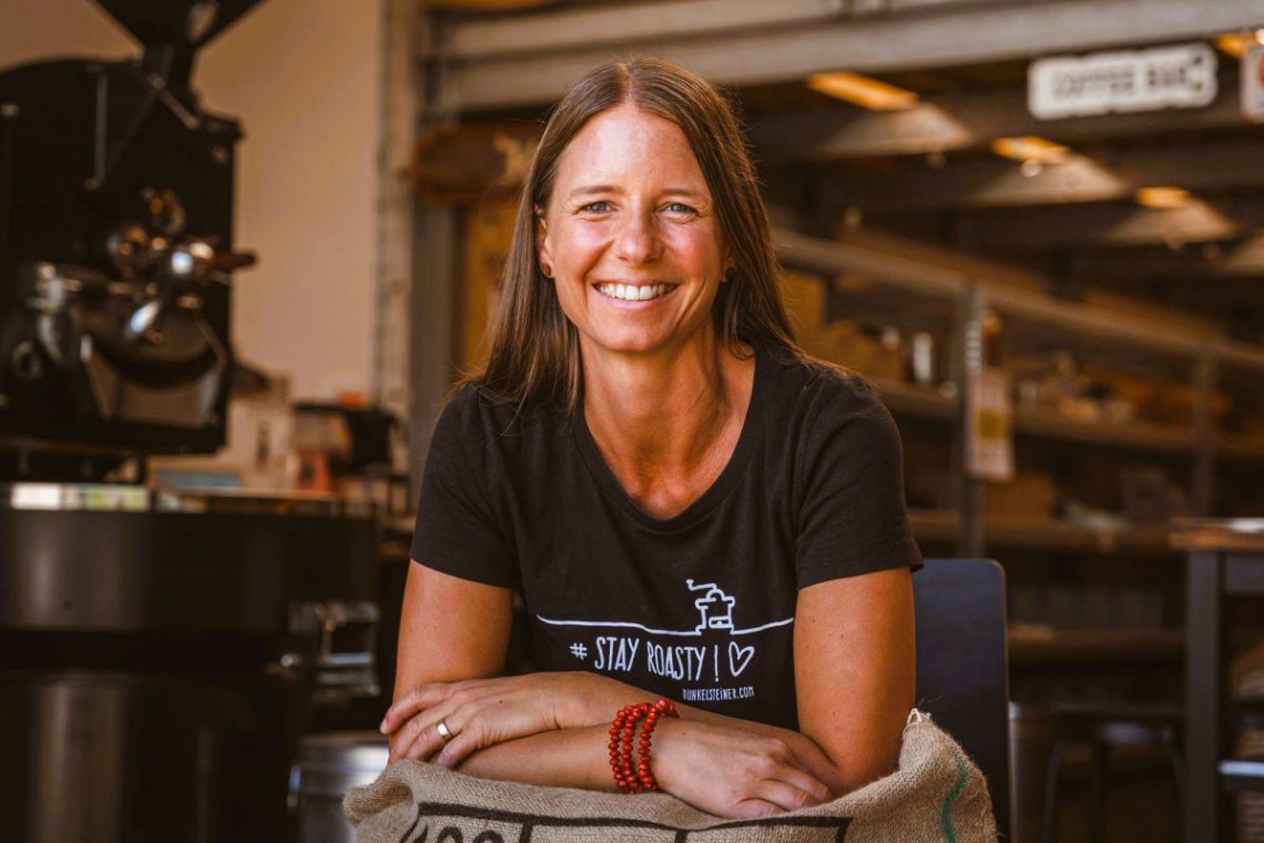 Petra Leitner lehnt sich auf Kaffeesack ab. Portraitfoto