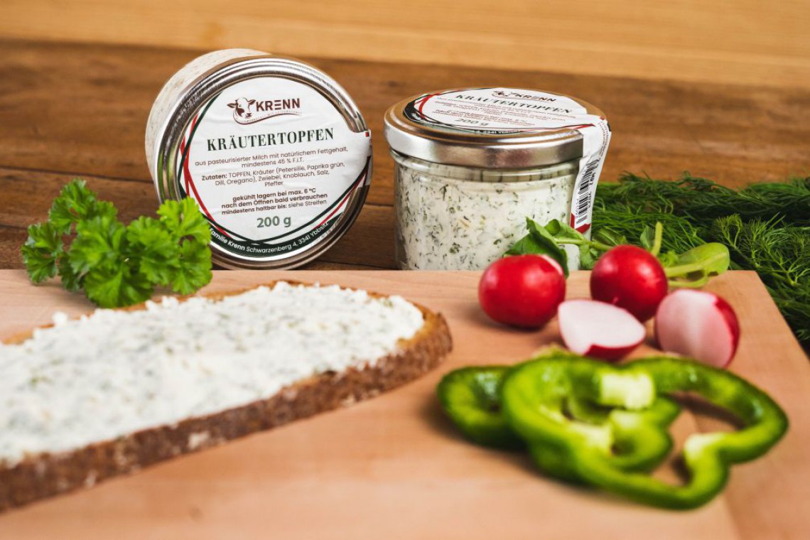 Aufstrichbrot mit Paprika und Radieschen und Aufstrichglas im Hintergrund