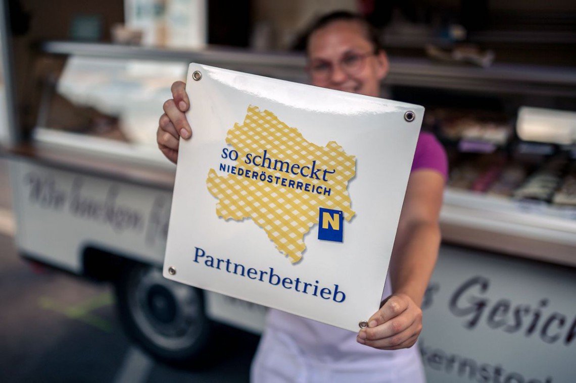 Frau hält Parterbetrieb-Plakette