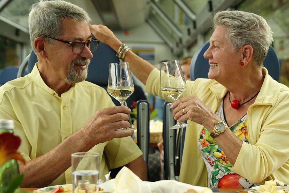 Ein Paar stoßt mit Weingläsern in der Mariazellerbahn an