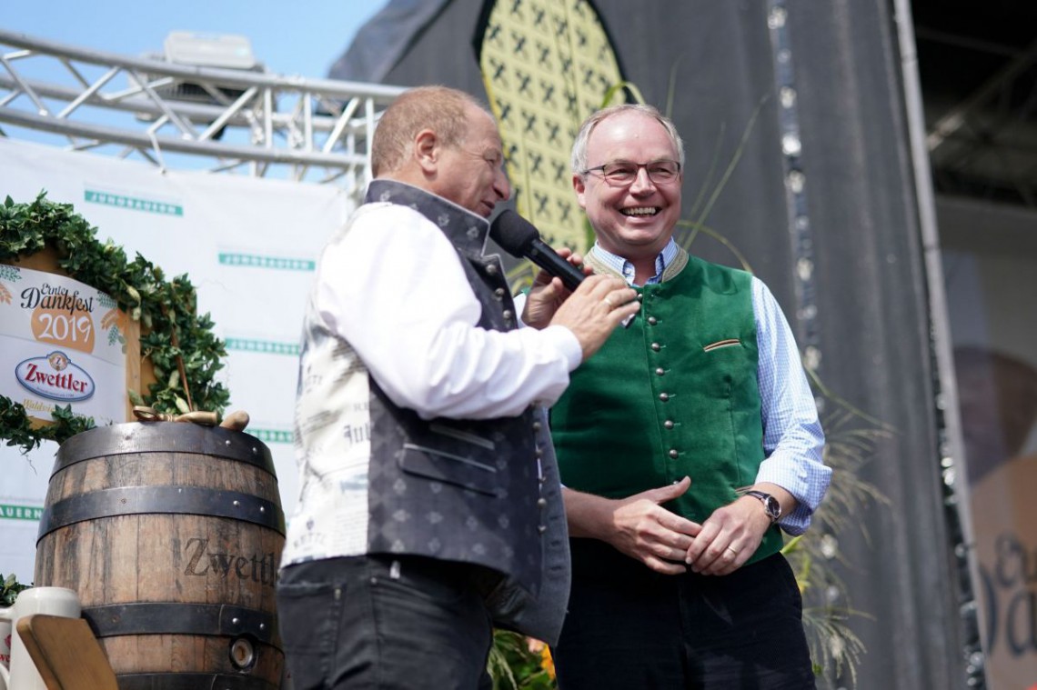 Landeshauptfrau-Stellvertreter Stephan Pernkopf steht gemeinsam mit einem Moderator auf der Bühne beim Erntedankfest