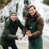 Bild anzeigen: Thorhof Marlene und Christian Kirchmayer vor Wasserfall mit Fisch in der Hand