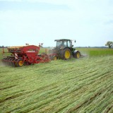 Bild anzeigen: Grand Farm, ein Traktor mit Zugmaschine am Feld