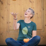 Bild anzeigen: Kürbishof Metz, Karin Metz sitzend mit Kürbis