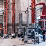 Bild anzeigen: Farthofer, Brennanlage mit Herrn Farthofer im Vordergrund