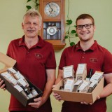 Bild anzeigen: Biohof Hofer, Familie Hofer präsentiert Geschenkkartons gefüllt mit eigenen Produkten