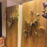 Bild anzeigen: Mei G´schäft, Wand mit Blumenkränzen
