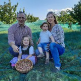 Bild anzeigen: Familie Rausch auf wiese mit Korb voll Haselnüssen