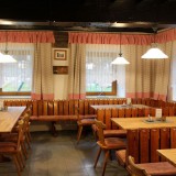 Bild anzeigen: Gem&uuml;tliche Gaststube mit Tischen und B&auml;nken