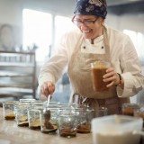 Bild anzeigen: Frau f&uuml;llt Essen in Gl&auml;ser ein