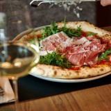 Bild anzeigen: Auf eine Pizza wird Parmesan gerieben