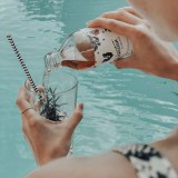 Bild anzeigen: B&auml;rnstein wir in ein Glas eingeschenkt, Pool im Hintergrund