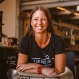 Bild anzeigen: Petra Leitner lehnt sich auf Kaffeesack ab. Portraitfoto