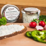 Bild anzeigen: Aufstrichbrot mit Paprika und Radieschen und Aufstrichglas im Hintergrund