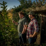 Bild anzeigen: Zwei M&auml;nner im Weingarten mit Achterl Wein in der Hand