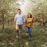 Bild anzeigen: Mathias und Nicole Frosch gehe zwischen Obstb&auml;ume spazieren