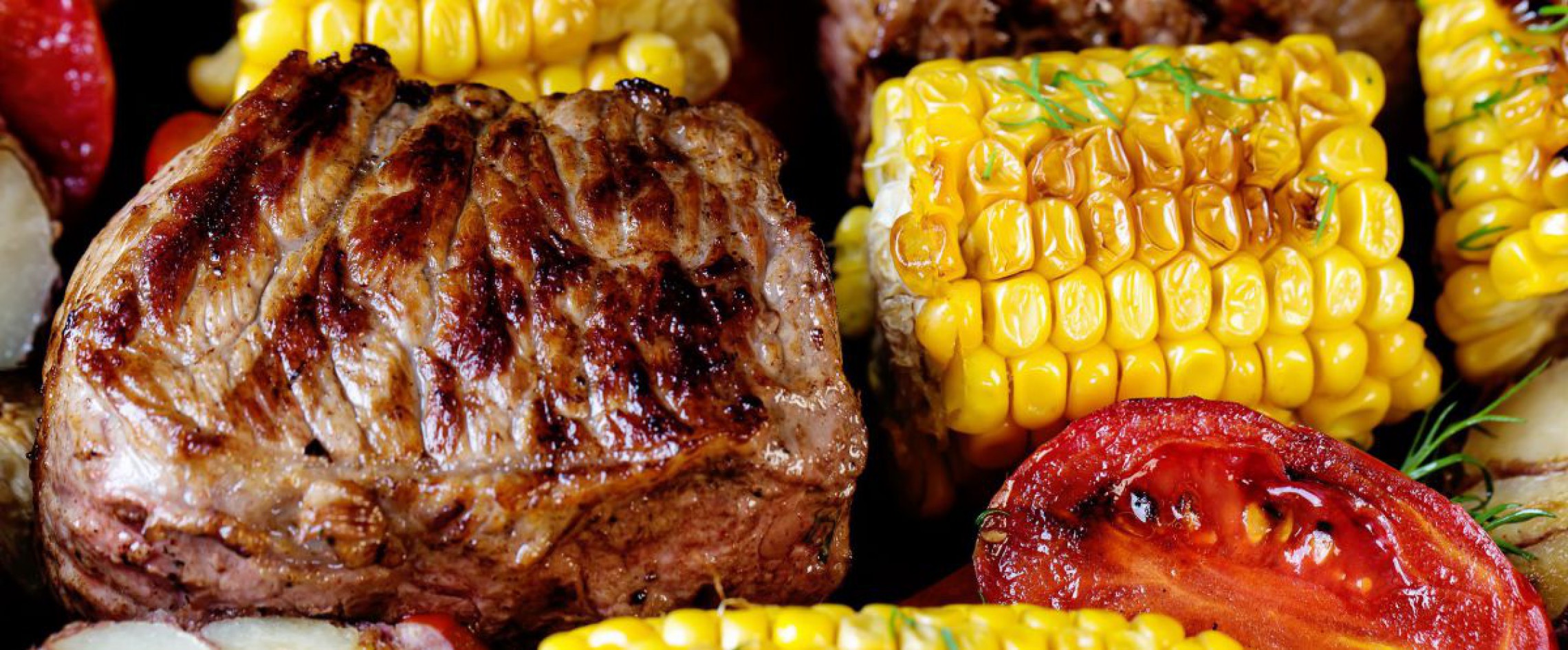 Rindfleisch, Mais und Tomaten am Grillrost