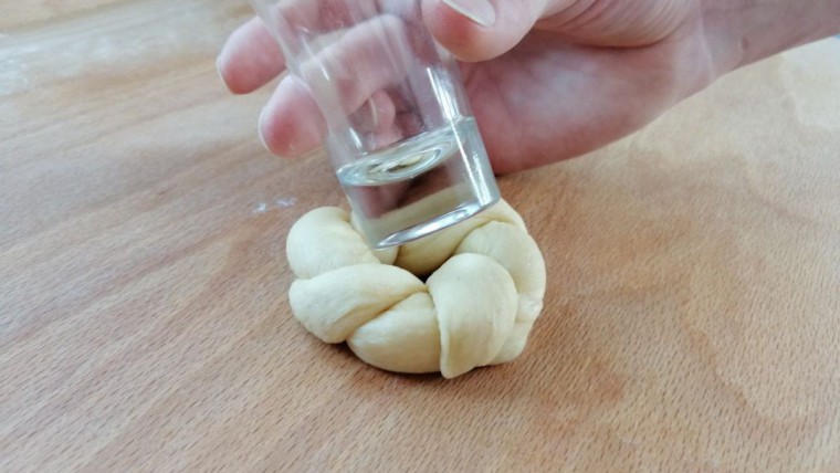 Germteig-Miniosternest wird mit einem Glas eingedrückt