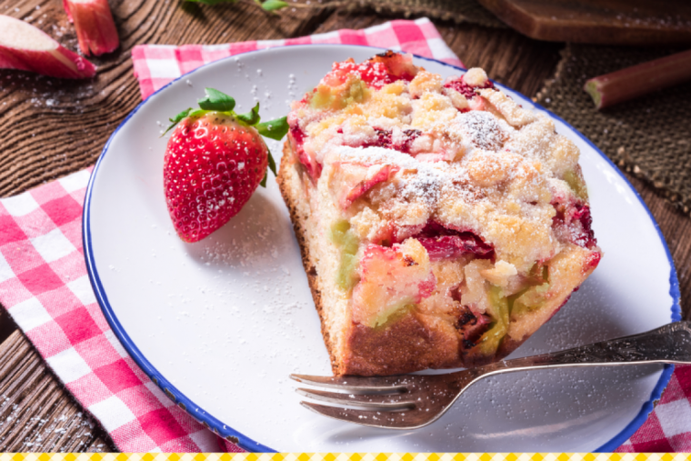 Rhabarber-Erdbeer-Kuchen auf einem Teller mit einer frischen Erdbeere und einer Gabel