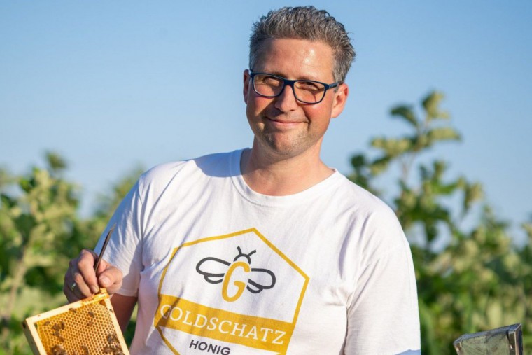 Andreas Steiner mit Honigwabe in der Hand