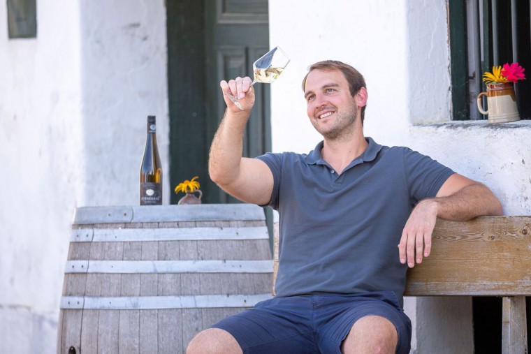 Herr F&uuml;rnkranz auf einer Bank schaut ein Glas Wein an