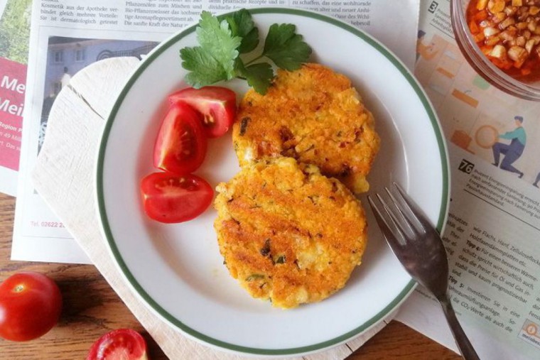 Hirsepatties mit Käse und Paradeiser auf einem Teller