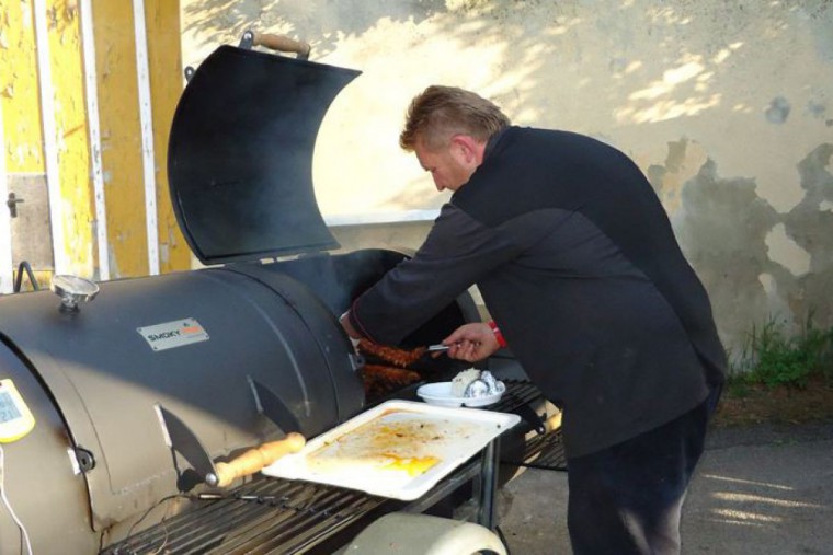 Griller mit Koch der Essen zubereitet