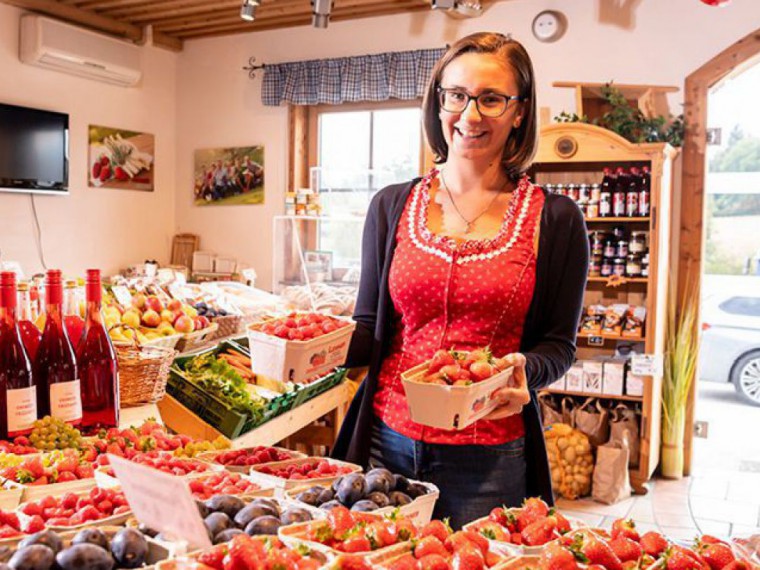 Dame beim Einkauf von frischen Erdbeeren im Beerenstadl der Familie Lehner