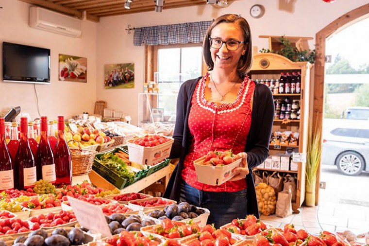 Dame beim Einkauf von frischen Erdbeeren im Beerenstadl der Familie Lehner